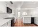 Kitchen showing terracotta tile floor, white cabinets, and black appliances at 3800 E Lincoln Dr # 7, Phoenix, AZ 85018