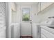 Bright laundry room featuring a washer, dryer, storage cabinets and access to the backyard at 3800 E Lincoln Dr # 7, Phoenix, AZ 85018