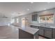Bright kitchen with gray cabinets, stainless steel appliances, an island, and a dining area by a sunny window at 3917 E Morenci Rd, San Tan Valley, AZ 85143