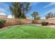 Backyard featuring artificial turf grass, desert landscaping, and a block wall for optimal privacy at 4013 E Woodland Dr, Phoenix, AZ 85048