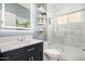 Bright bathroom with a modern vanity, glass enclosed shower, decorative shelving, and white marble walls at 4013 E Woodland Dr, Phoenix, AZ 85048