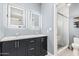Modern bathroom with double vanity, framed mirrors, and a walk-in shower featuring white subway tile at 4013 E Woodland Dr, Phoenix, AZ 85048