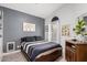 Bedroom with a queen bed, gray accent wall, neutral flooring, and a window letting in lots of natural light at 4013 E Woodland Dr, Phoenix, AZ 85048
