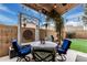 Covered patio with seating area, privacy wall, green turf and lovely decorative touches and string lights at 4013 E Woodland Dr, Phoenix, AZ 85048