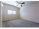 Bright bedroom with plush carpet, ceiling fan, and ample natural light from window at 412 W Fairhaven Rd, Kearny, AZ 85137