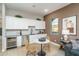 Cozy kitchenette with white cabinets, stainless steel appliances, and a stylish dining table at 43720 N Acadia Way, New River, AZ 85087