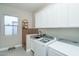 Functional laundry room with modern washer, dryer, and ample storage cabinets at 43720 N Acadia Way, New River, AZ 85087