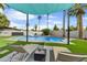 Beautifully landscaped backyard with a pool, sunshade, and lounge chairs, perfect for summer relaxation at 6525 N 83Rd St, Scottsdale, AZ 85250