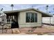 Charming manufactured home featuring a covered porch and carport, surrounded by desert landscaping and palm trees at 7300 N 51St Ave # B245, Glendale, AZ 85301