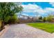 Paver patio and lawn with block wall, mature trees and view of neighboring home at 7975 W Andrea Dr, Peoria, AZ 85383