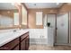 Bathroom features a bathtub, shower with glass doors, and double sinks with vanity at 7975 W Andrea Dr, Peoria, AZ 85383