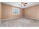 Neutral bedroom features carpeted flooring, a ceiling fan, and a window with plantation shutters at 7975 W Andrea Dr, Peoria, AZ 85383