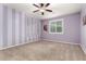Striped bedroom featuring carpet flooring, ceiling fan, and a large window at 7975 W Andrea Dr, Peoria, AZ 85383