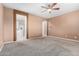Bedroom with carpeted flooring, ceiling fan, and access to the ensuite bathroom at 7975 W Andrea Dr, Peoria, AZ 85383