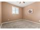 Neutral bedroom with a ceiling fan, carpeted floor, and shuttered window at 7975 W Andrea Dr, Peoria, AZ 85383