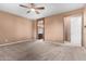 Spacious bedroom features carpeted flooring, access to the ensuite bathroom, and a ceiling fan at 7975 W Andrea Dr, Peoria, AZ 85383