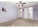 Purple bedroom with carpet flooring, ceiling fan, and easy access to the connected bathroom at 7975 W Andrea Dr, Peoria, AZ 85383