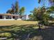 Wide backyard with a white house, covered patio, chimney, and mature trees at 8002 N 5Th Ave, Phoenix, AZ 85021