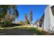 Open backyard with a white house, a covered patio, chimney, mature trees and fence at 8002 N 5Th Ave, Phoenix, AZ 85021