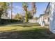 Spacious backyard with an iron fence, mature trees, and a covered patio at 8002 N 5Th Ave, Phoenix, AZ 85021