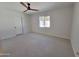 Spacious bedroom featuring soft carpet, a ceiling fan, and a window allowing ample natural light at 8002 N 5Th Ave, Phoenix, AZ 85021