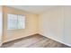 An empty bedroom features neutral walls, wood flooring, and a window with blinds at 828 W Laguna Dr, Tempe, AZ 85282
