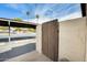 View of parking and wooden gate to property, palm trees and community area beyond at 828 W Laguna Dr, Tempe, AZ 85282