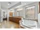 Bright bathroom with double sinks, custom cabinets, and soaking tub at 9869 E Davenport Dr, Scottsdale, AZ 85260