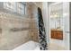 Bathroom bathtub/shower with custom tile work, decorative window and a view to the vanity at 9869 E Davenport Dr, Scottsdale, AZ 85260