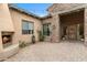 Charming outdoor courtyard featuring a stone fireplace, paved patio, and arched entryways at 9869 E Davenport Dr, Scottsdale, AZ 85260