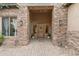 Inviting front entrance featuring a stone facade, custom wood door, and sidelight windows at 9869 E Davenport Dr, Scottsdale, AZ 85260