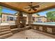Outdoor entertaining with a covered bar area with a built-in fireplace, overlooking a pool and spa at 9869 E Davenport Dr, Scottsdale, AZ 85260