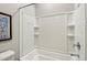 White tiled bathtub and shower combination with built in shelving and chrome shower head at 9923 E Texas Ave, Mesa, AZ 85212