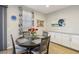 Cozy dining area featuring a round table, four chairs, and stylish decor, adjacent to bright windows at 9923 E Texas Ave, Mesa, AZ 85212