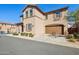 Spacious two-car garage attached to a stucco home, enhanced by tidy landscaping and a clear blue sky at 9923 E Texas Ave, Mesa, AZ 85212