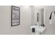 Modern powder room with a stylish pedestal sink, elegant mirror, and contemporary decor for added convenience at 1111 E Missouri Ave # 9, Phoenix, AZ 85014