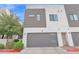 Modern townhome exterior featuring a garage, neutral siding, and landscaping at 1111 E Missouri Ave # 9, Phoenix, AZ 85014