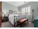 Cozy bedroom features a wrought iron bed frame, white bedding, and plantation shutters at 11123 E Olla Ave, Mesa, AZ 85212
