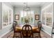 Dining room with a wooden round table, four chairs, shutters, and modern lighting fixture at 11123 E Olla Ave, Mesa, AZ 85212