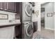The Laundry Room has a modern stacked washer/dryer, solid surface countertops and storage cabinets at 11123 E Olla Ave, Mesa, AZ 85212