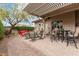 A view of a large backyard patio with brick pavers, seating areas, and outdoor shade at 11123 E Olla Ave, Mesa, AZ 85212