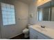 This bathroom features a vanity sink with a mirror and a glass block window for natural light at 11189 W Cameo Dr, Sun City, AZ 85351