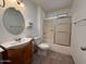 This bathroom features a shower/tub combo and a vanity with an oval mirror and wood cabinets at 11189 W Cameo Dr, Sun City, AZ 85351