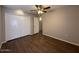 This bedroom features a ceiling fan, wood-look floors, and a closet with white doors at 11189 W Cameo Dr, Sun City, AZ 85351
