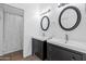 Bathroom featuring dual sinks, dark wood cabinetry, round mirrors, and a shower with patterned curtain at 11260 N 92Nd St # 1060, Scottsdale, AZ 85260