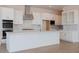 Bright kitchen featuring white cabinets, stainless steel appliances, and island with gold fixtures at 1254 E Penedes Dr, Gilbert, AZ 85298
