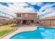 Backyard with pool, grassy area, and covered patio, perfect for entertaining or relaxing on warm summer days at 12574 W Desert Rose Rd, Avondale, AZ 85392