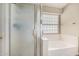 Bathroom showcases a frosted glass shower, bathtub, and a window offering natural light at 12574 W Desert Rose Rd, Avondale, AZ 85392
