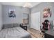 Bedroom with gray walls, wood-look floors, ceiling fan, and a window for natural light at 12574 W Desert Rose Rd, Avondale, AZ 85392