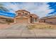 Two-story tan stucco home with a tile roof, two-car garage, and desert landscaping at 12574 W Desert Rose Rd, Avondale, AZ 85392